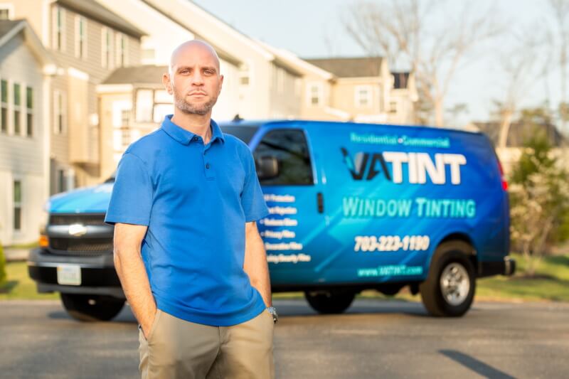 Man in blue shirt in front of VA Tint commercial van